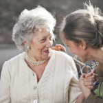 Νεαρή κοπέλα και ηλικιωμένη γυναίκα συζητούν